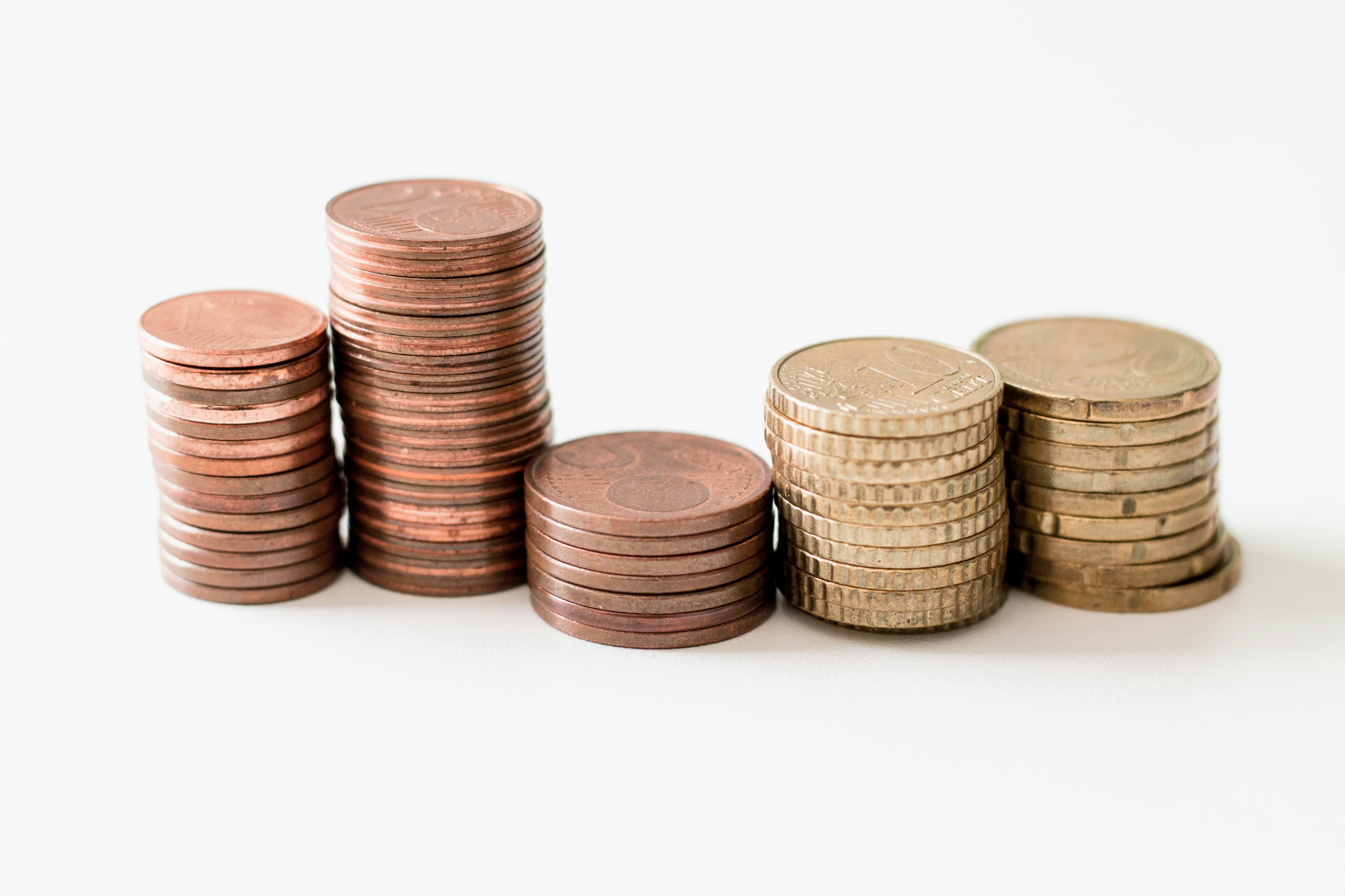 A stack of gold-colored coins on a white surface