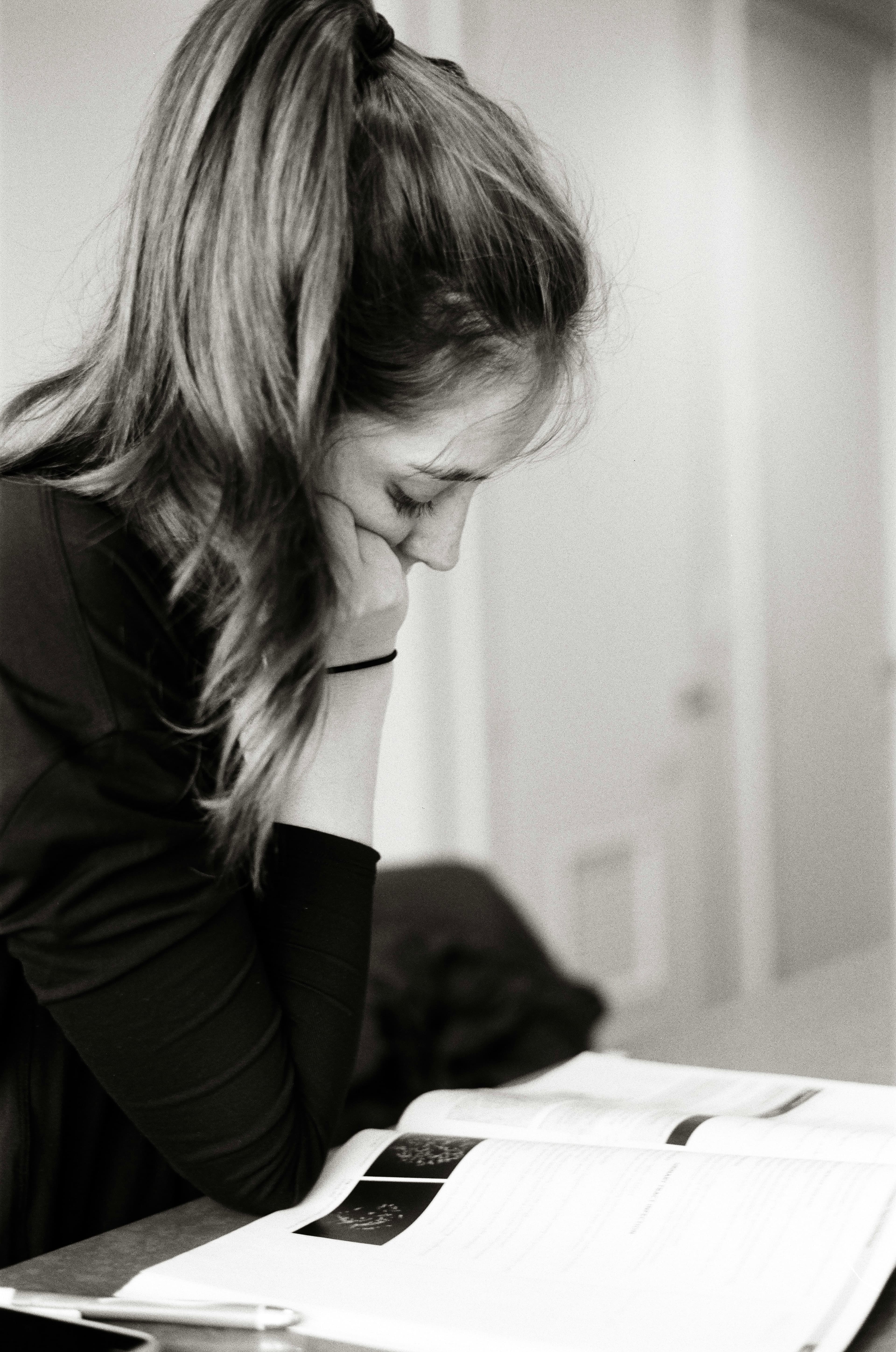 A student resting her head on her hand beside an open book
