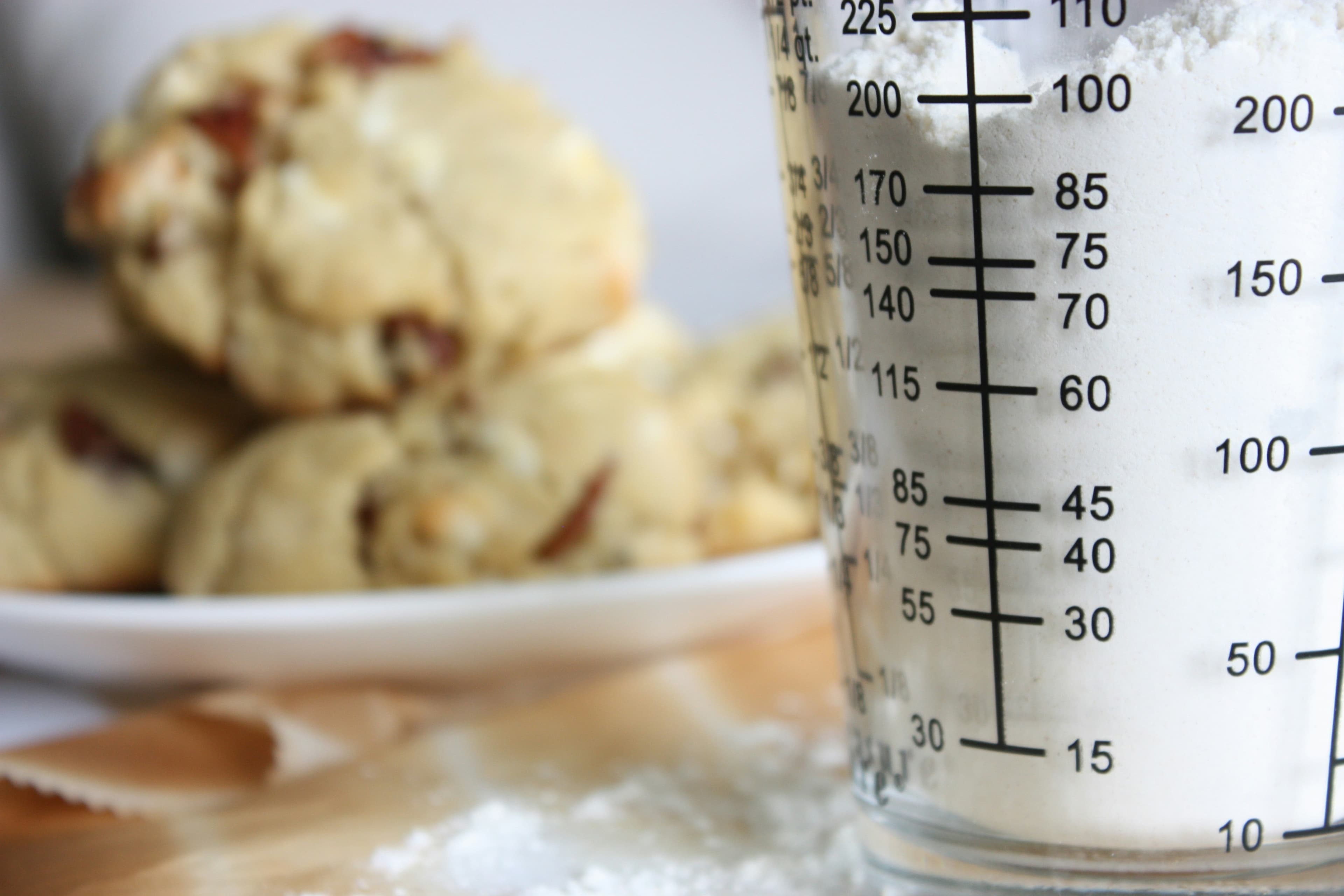 A clear glass measuring cup on a white ceramic plate