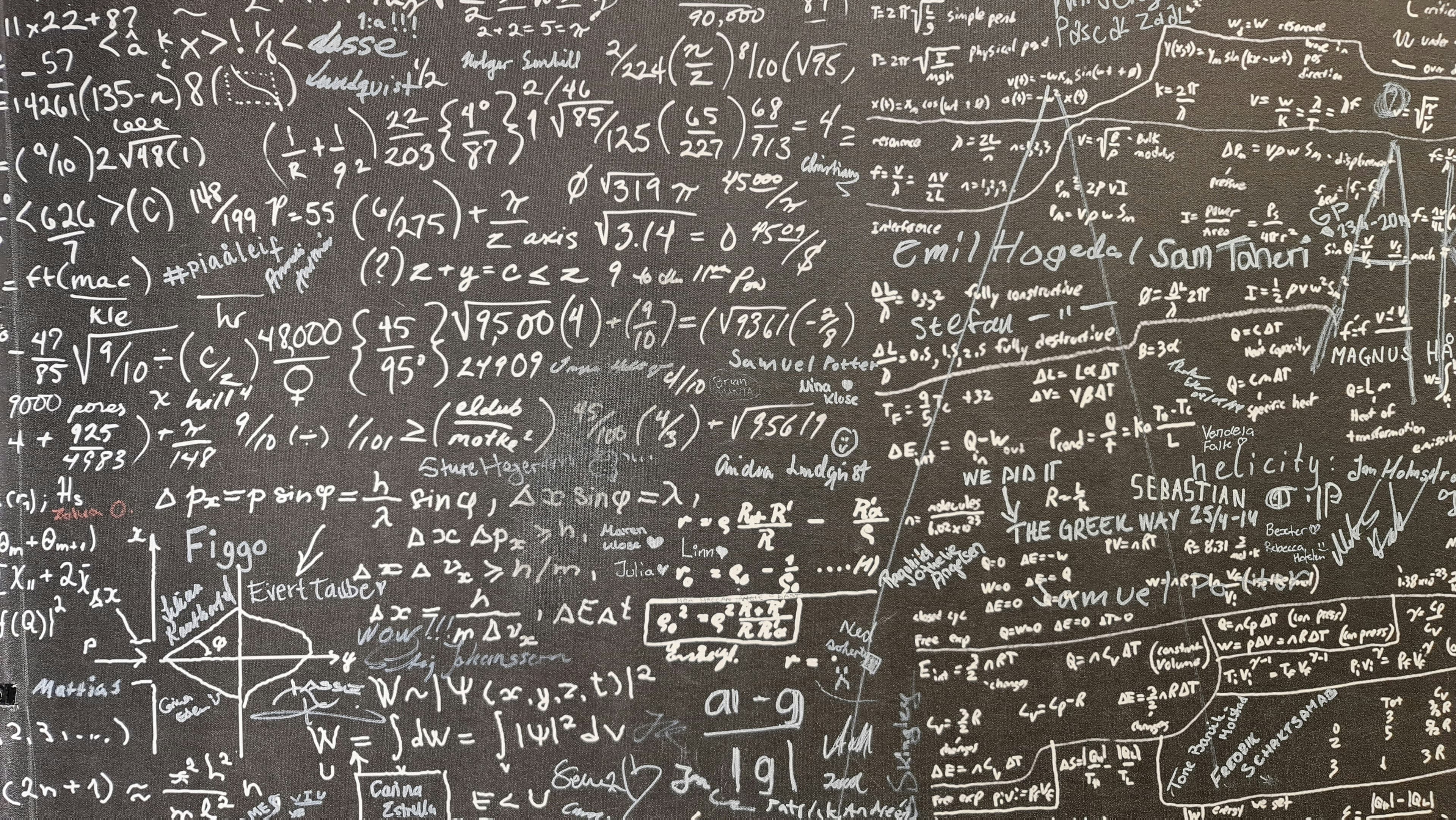 A blackboard covered in handwritten math