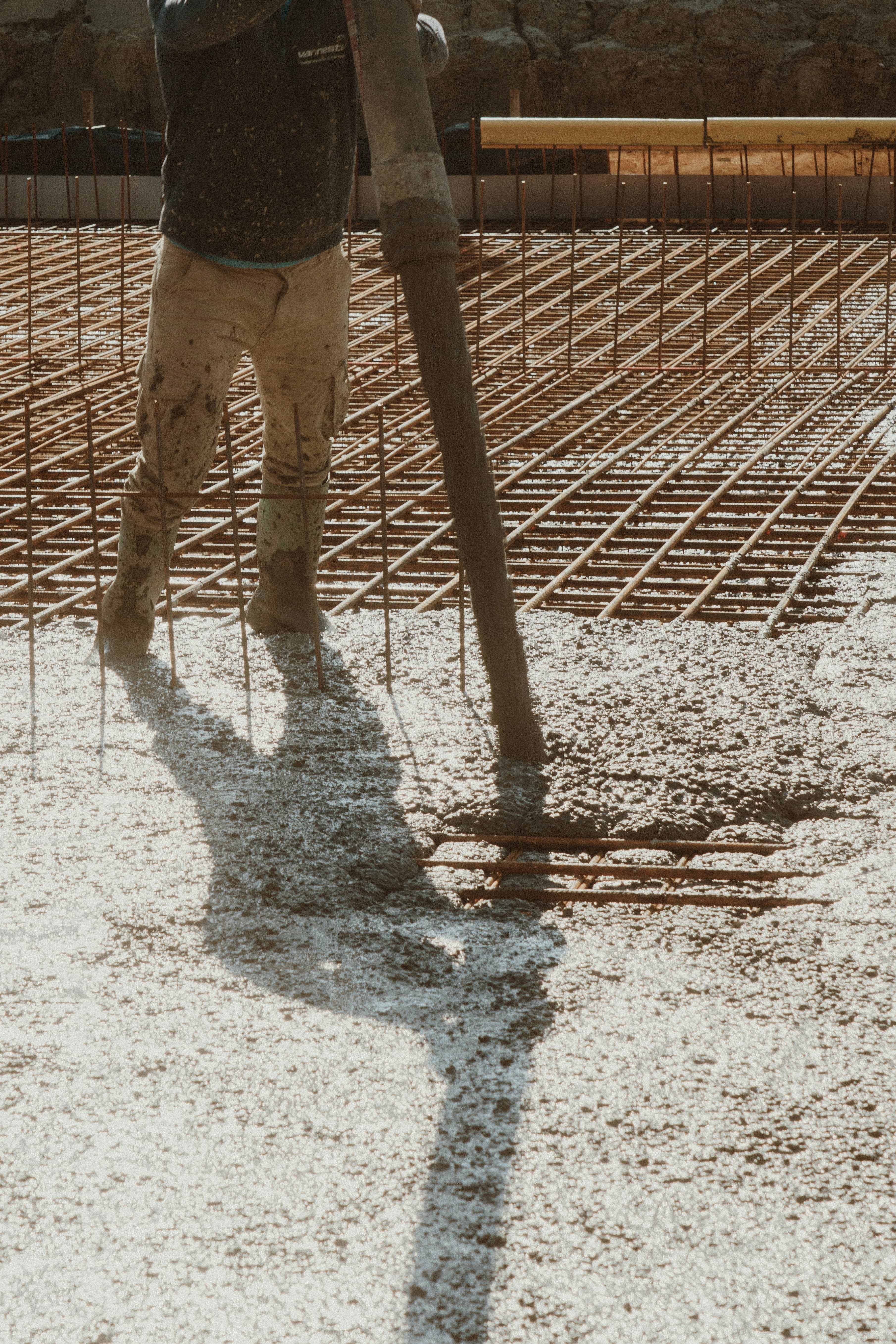 A man standing on a freshly poured concrete slab