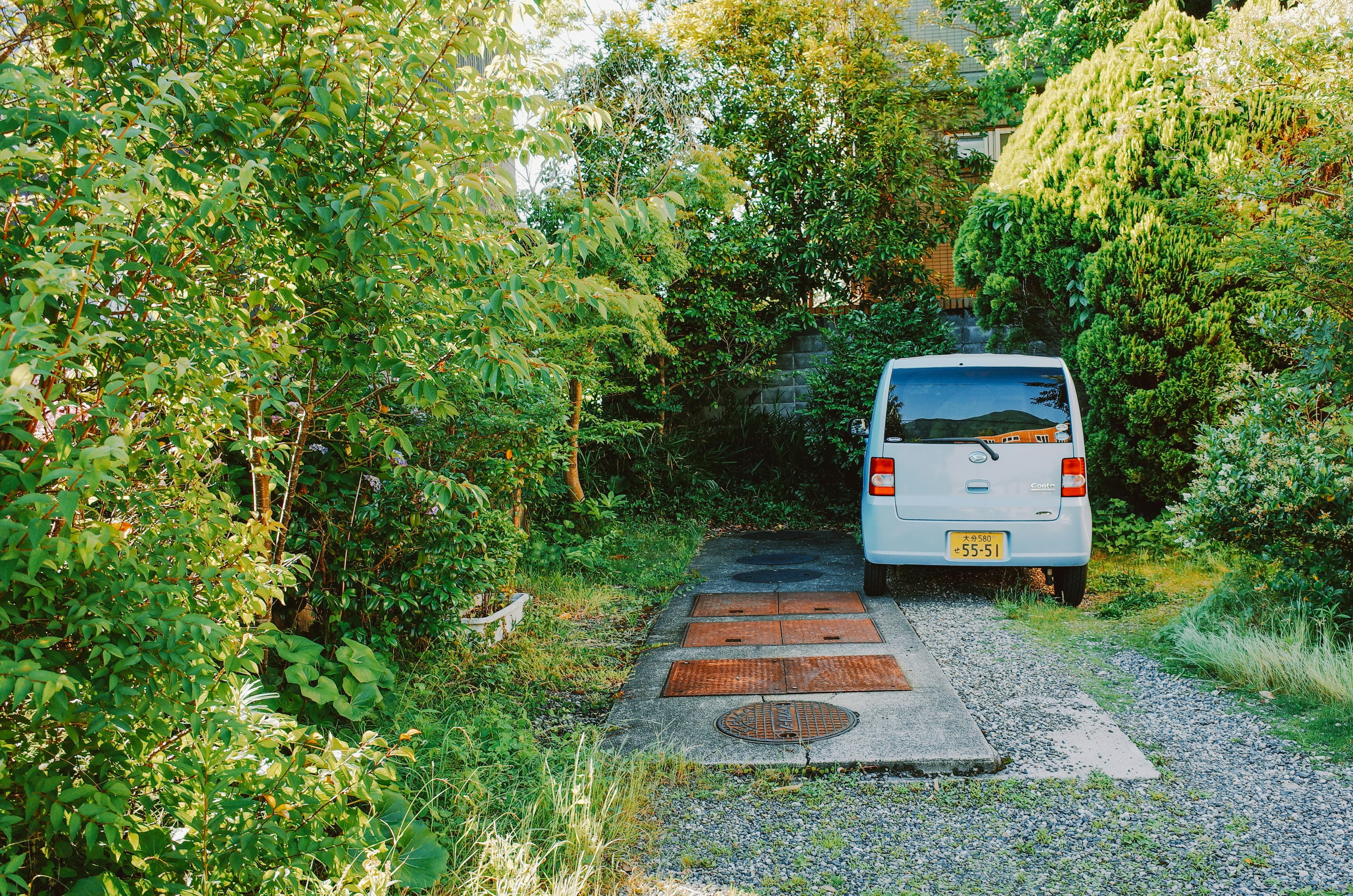 A light blue van parked on a gravel driveway