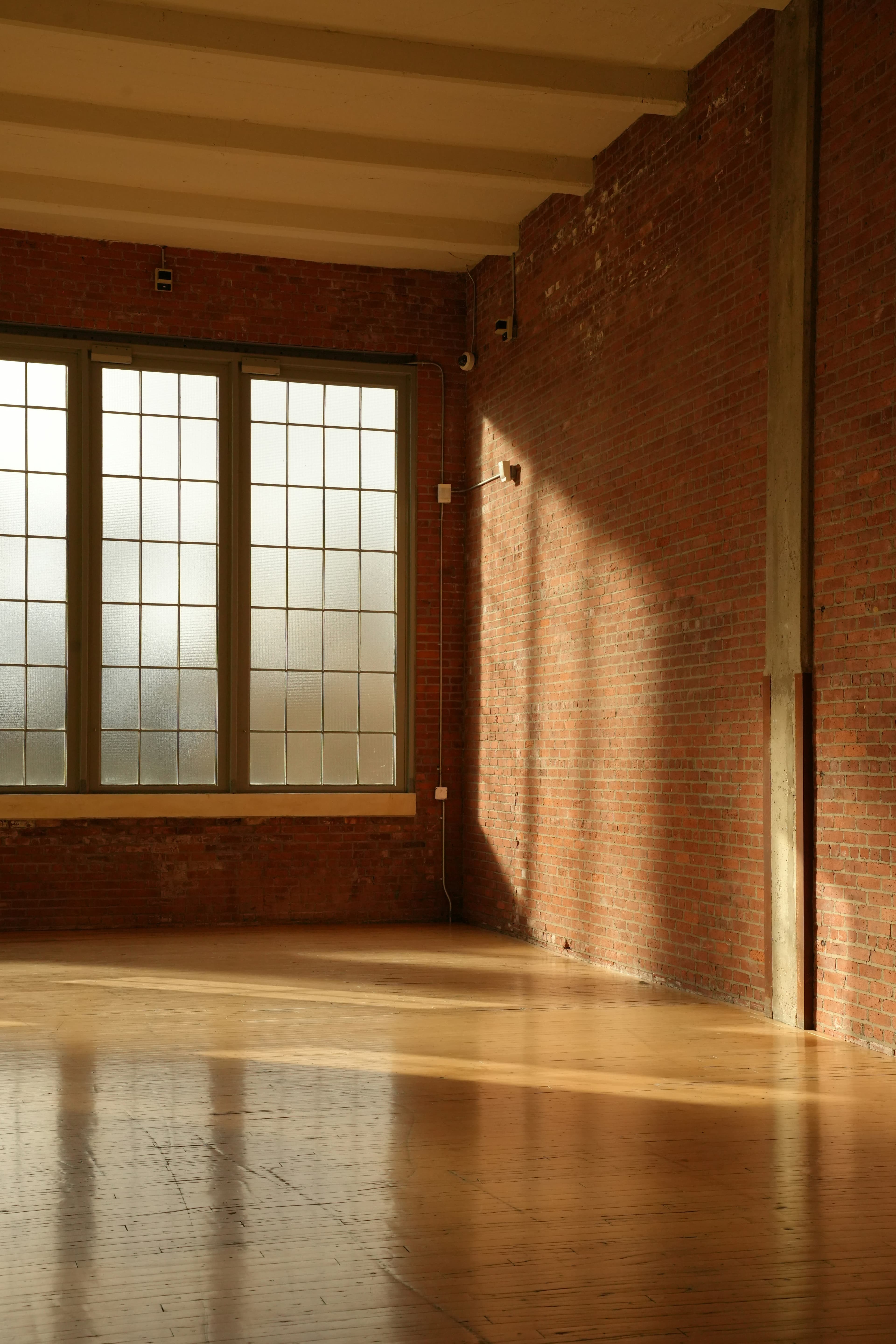 Sunlight streaming through a large window onto a wooden floor