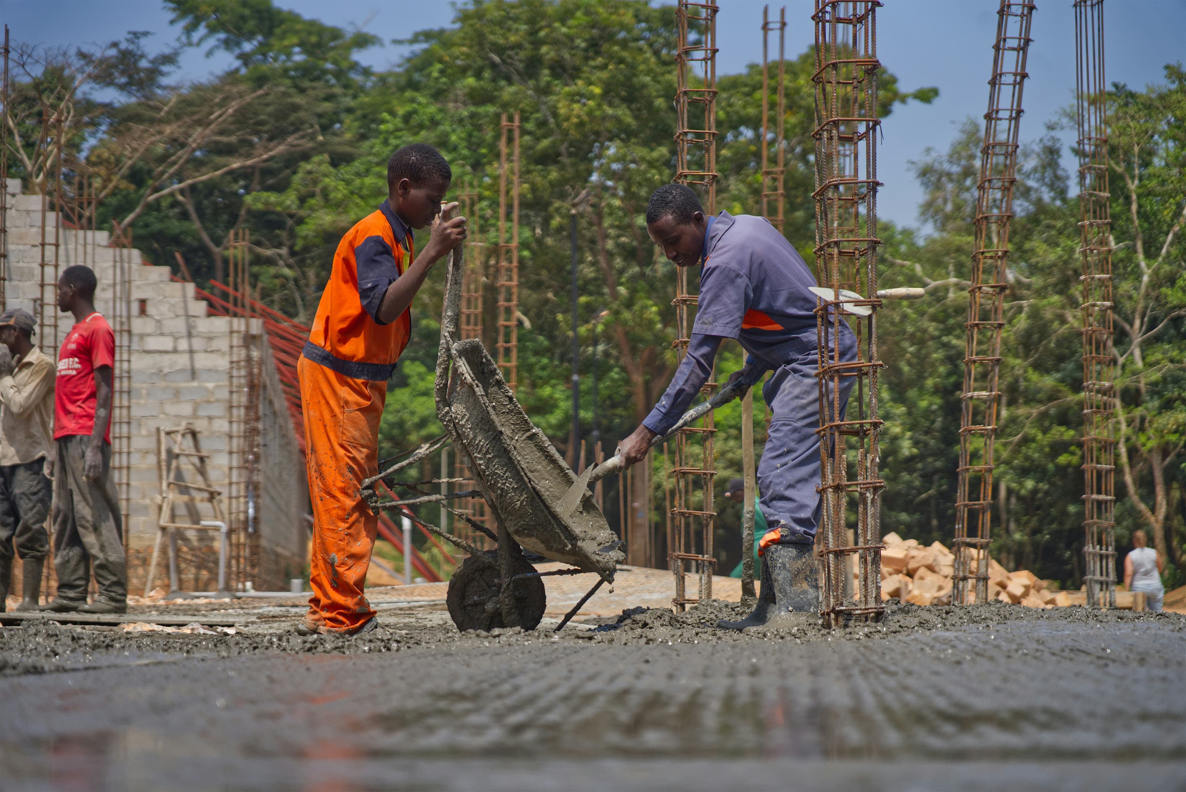 Construction workers pouring concrete from a wheelbarrow