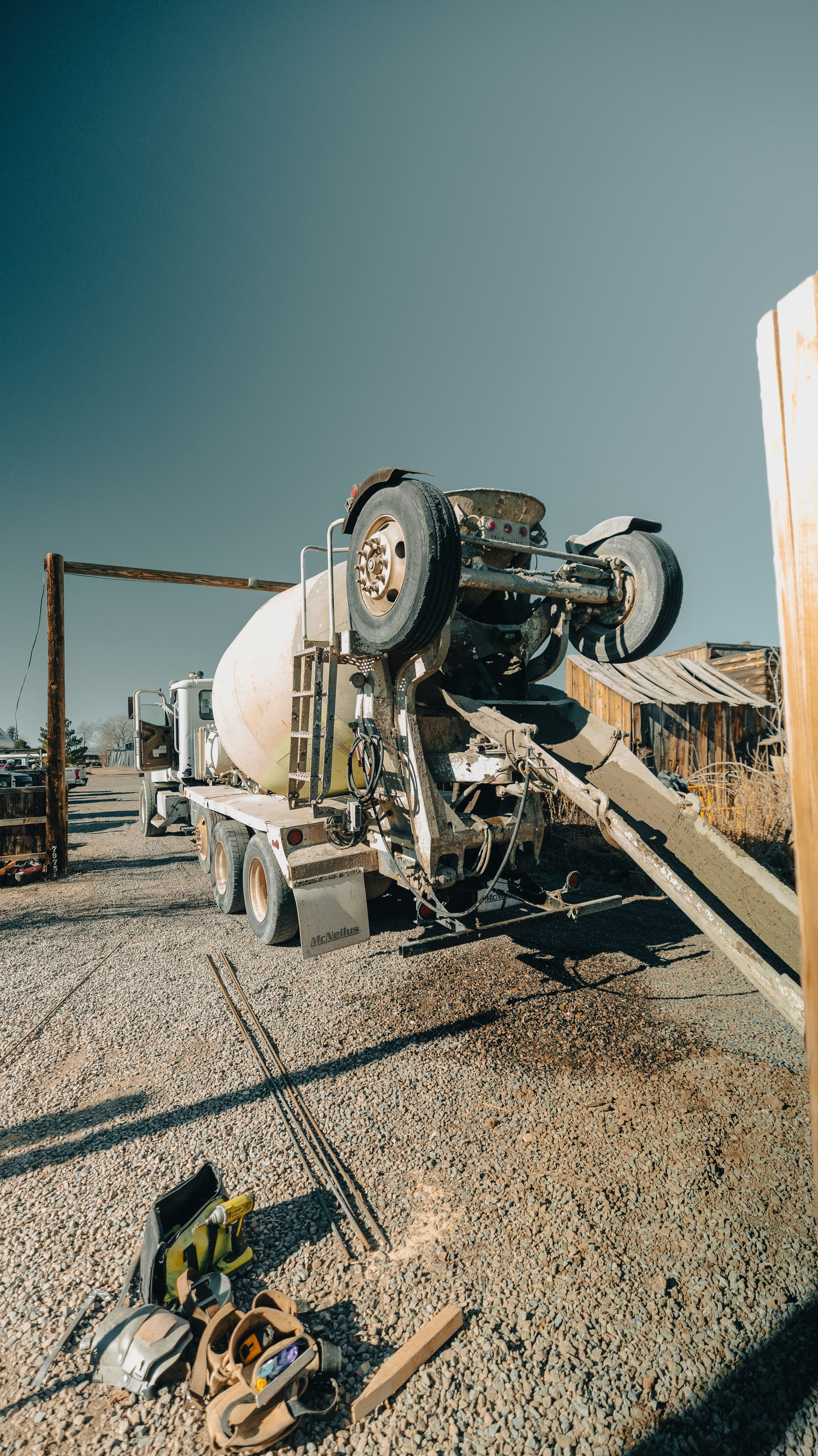 A cement truck parked on a gravel lot with tools