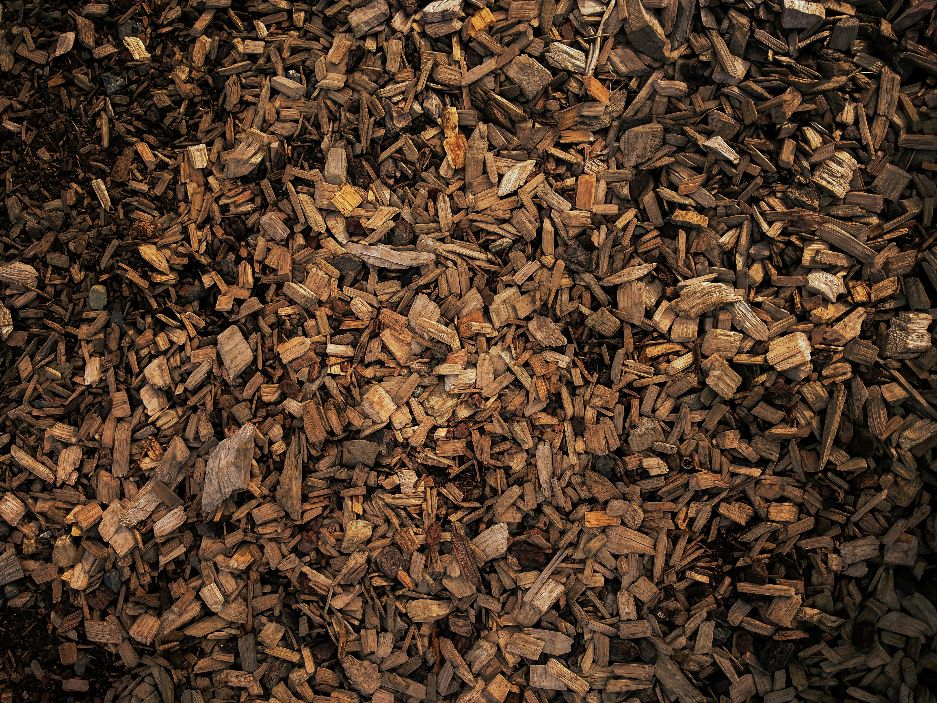A large pile of brown wood chip mulch